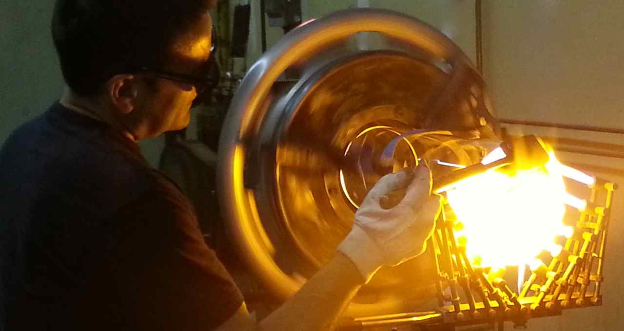 Ross North, master glass blower putting a flange on glass cylinder